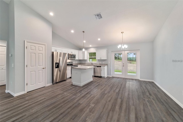 kitchen with stainless steel appliances, white cabinets, light countertops, a center island, and decorative light fixtures