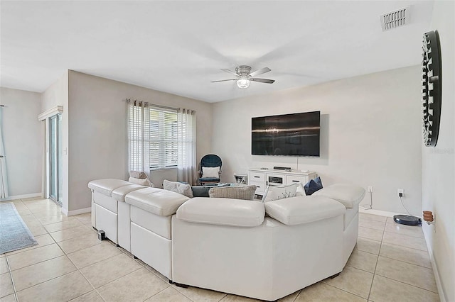 living area with ceiling fan, light tile patterned flooring, visible vents, and baseboards