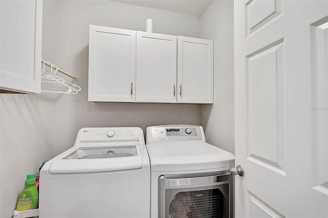 washroom featuring cabinet space and washing machine and clothes dryer