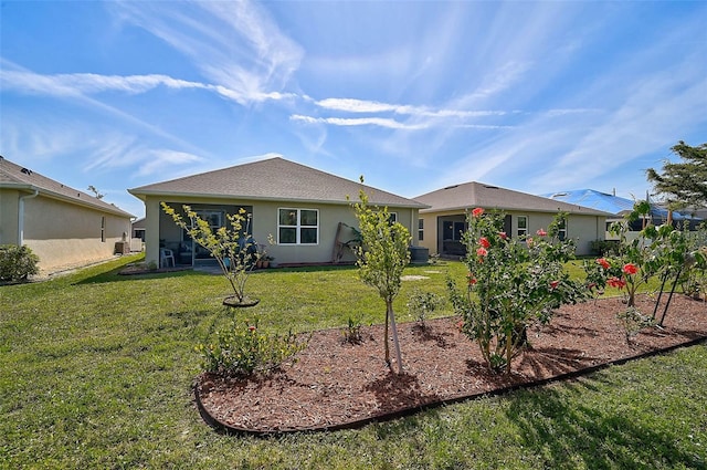 back of property featuring central AC, a lawn, and stucco siding