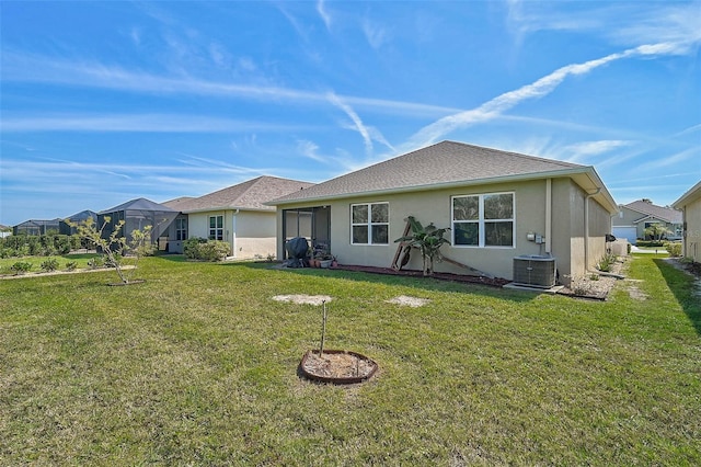 rear view of house featuring central air condition unit, a lawn, and stucco siding