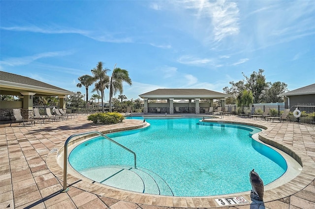 pool with fence, a patio, and a gazebo