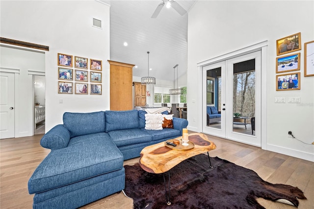 living room featuring high vaulted ceiling, visible vents, and light wood-style floors