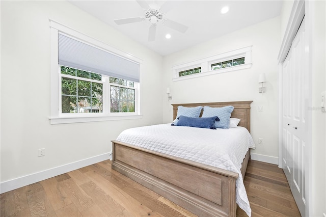 bedroom featuring ceiling fan, recessed lighting, wood finished floors, baseboards, and a closet