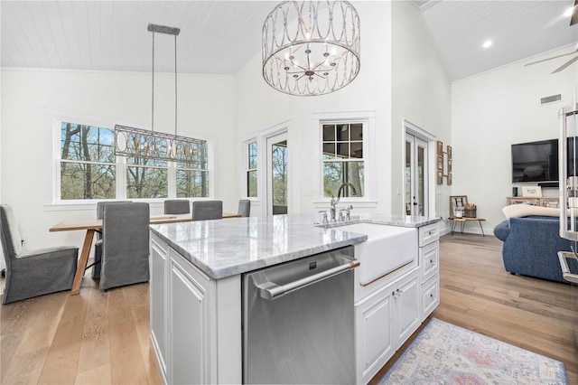 kitchen featuring pendant lighting, an inviting chandelier, open floor plan, white cabinets, and dishwasher