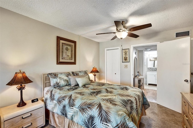 bedroom featuring visible vents, ceiling fan, a textured ceiling, carpet floors, and a closet