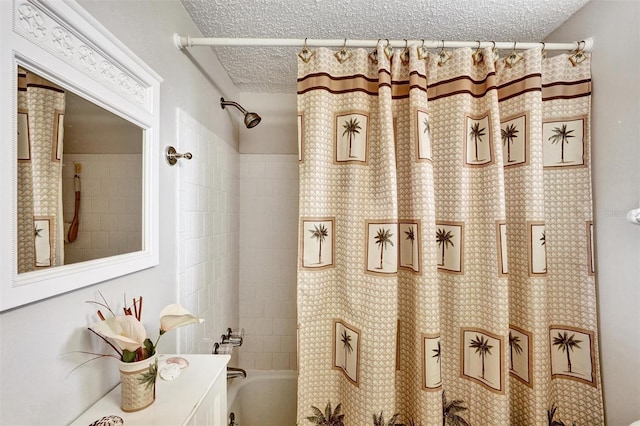 bathroom with a textured ceiling, vanity, and shower / tub combo with curtain