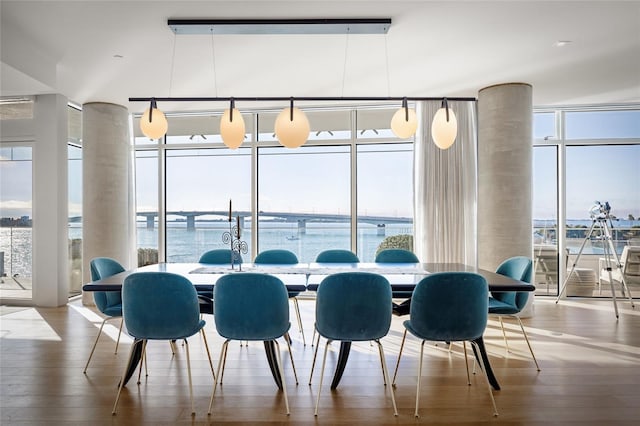 dining space with a wall of windows and wood finished floors