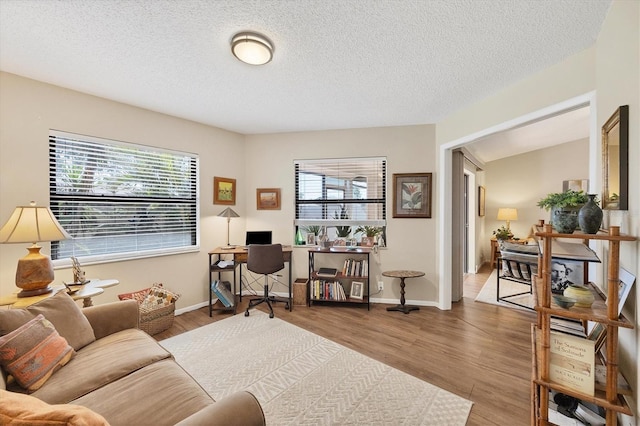 office featuring a textured ceiling, wood finished floors, and baseboards