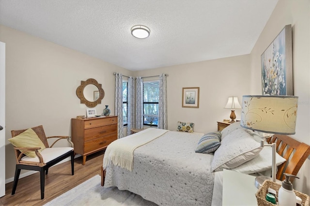 bedroom featuring a textured ceiling and wood finished floors