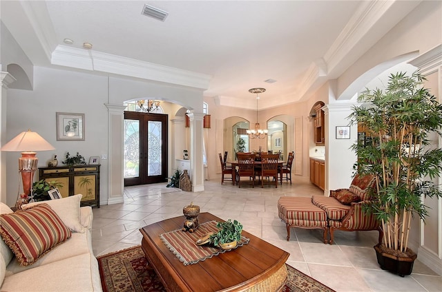 living area with arched walkways, visible vents, french doors, and ornamental molding