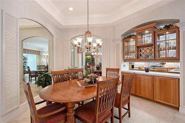 dining area with light tile patterned flooring, recessed lighting, arched walkways, ornamental molding, and a chandelier