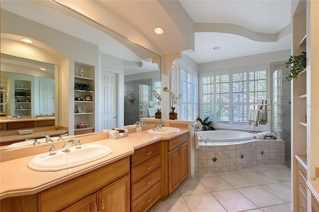 bathroom with a garden tub, a stall shower, a sink, tile patterned flooring, and double vanity