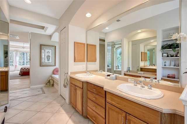 ensuite bathroom with tile patterned floors, double vanity, ensuite bathroom, and a sink