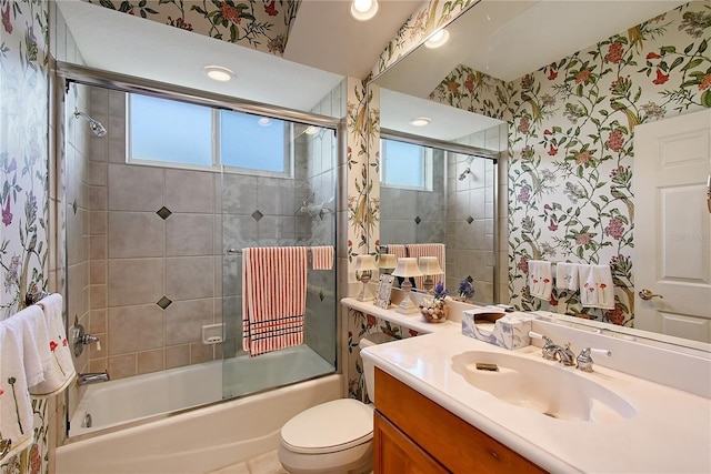 full bath with plenty of natural light, wallpapered walls, vanity, and bath / shower combo with glass door