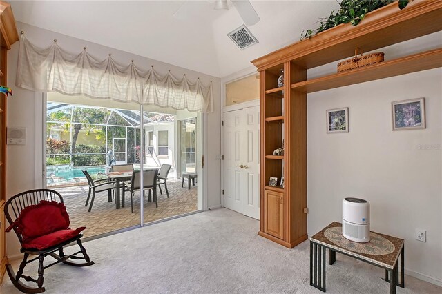 living area featuring visible vents, light colored carpet, ceiling fan, and a sunroom