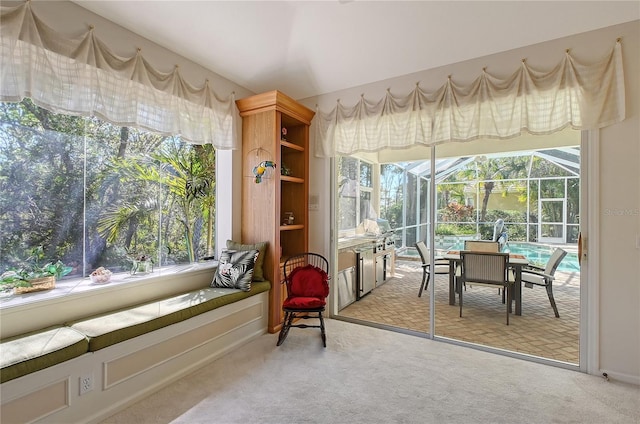 interior space featuring a sunroom and light carpet