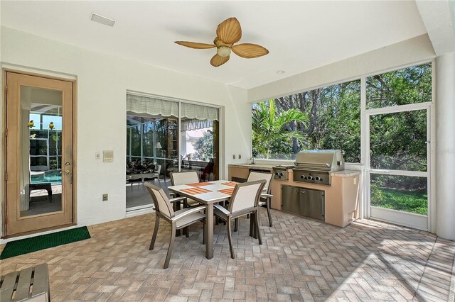 sunroom with a ceiling fan and visible vents