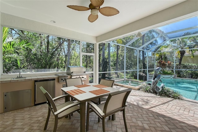 sunroom with ceiling fan and a sink