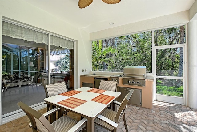 sunroom / solarium featuring ceiling fan and a sink