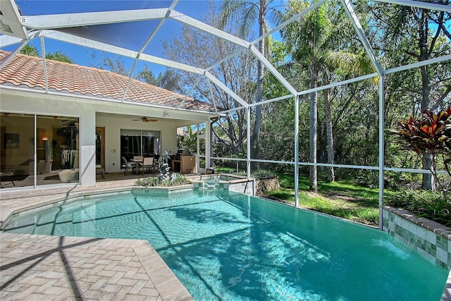 view of pool with glass enclosure, a patio, ceiling fan, and a pool with connected hot tub