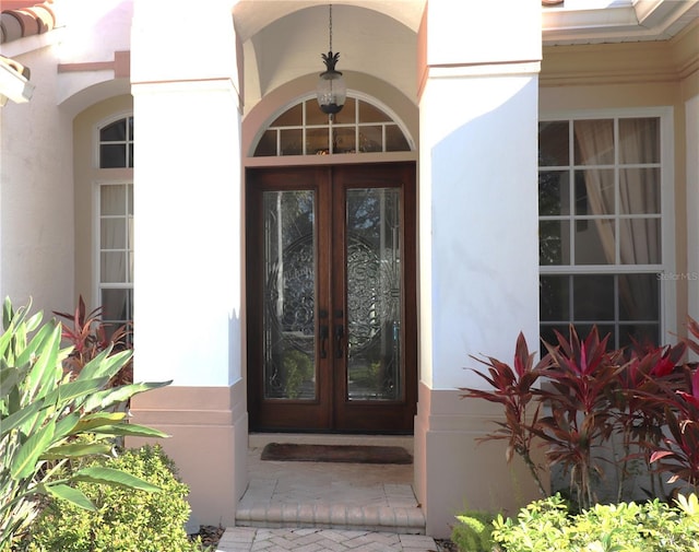 entrance to property featuring stucco siding and french doors