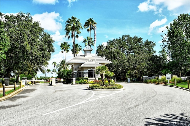 view of road featuring a gated entry, curbs, and a gate