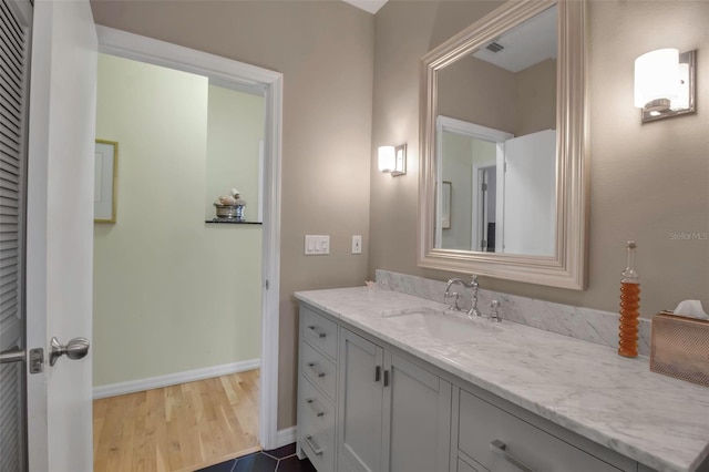 bathroom featuring vanity, baseboards, and wood finished floors