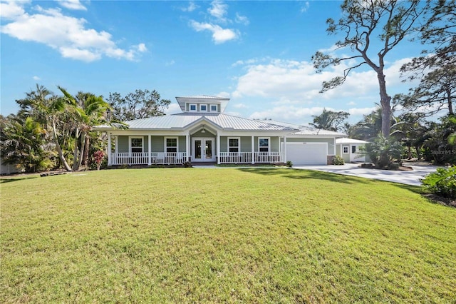 view of front facade with driveway, a garage, a front lawn, and french doors