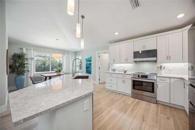 kitchen with white cabinetry, a center island with sink, and electric range