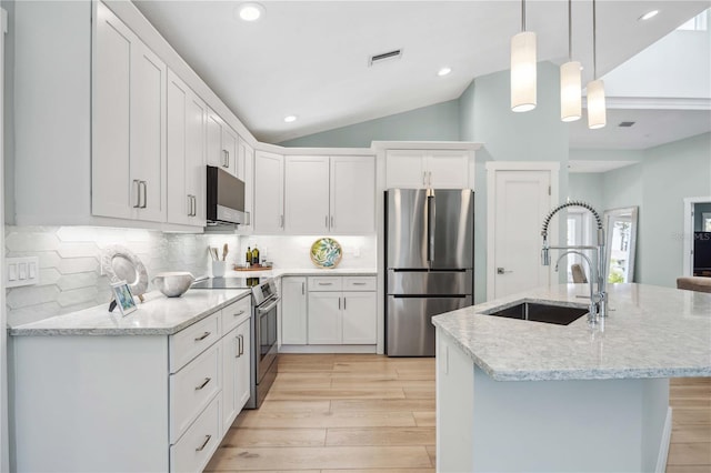 kitchen with stainless steel appliances, hanging light fixtures, a sink, and white cabinetry