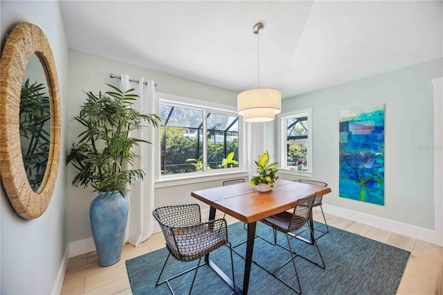 dining space with light wood finished floors and baseboards