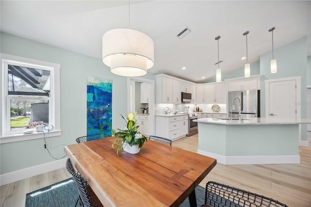 dining area with light wood finished floors, lofted ceiling, recessed lighting, visible vents, and baseboards