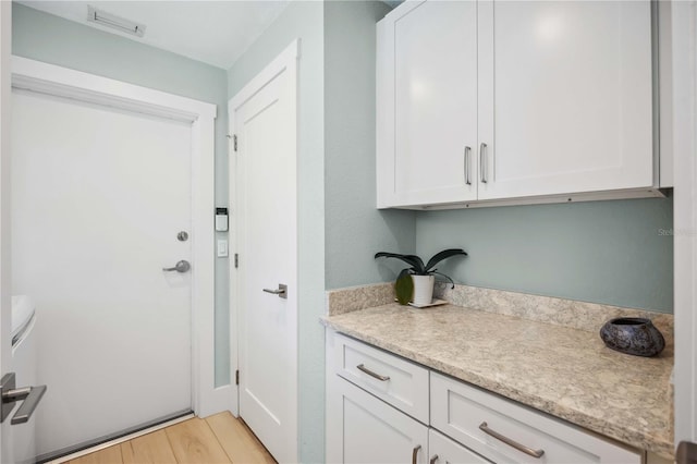 interior space featuring light wood-type flooring, light countertops, and white cabinets