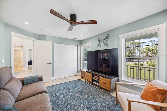 living area with light wood-style floors, plenty of natural light, and recessed lighting