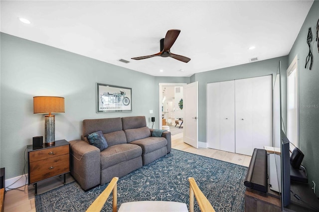 living area featuring baseboards, ceiling fan, visible vents, and wood finished floors