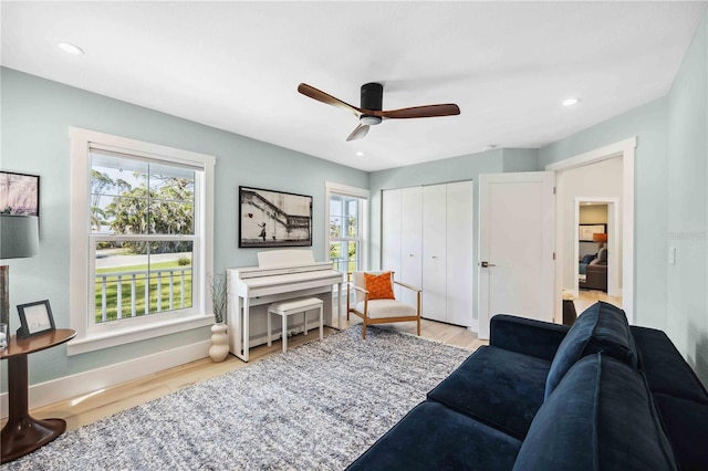 living area with light wood-type flooring, a wealth of natural light, ceiling fan, and recessed lighting