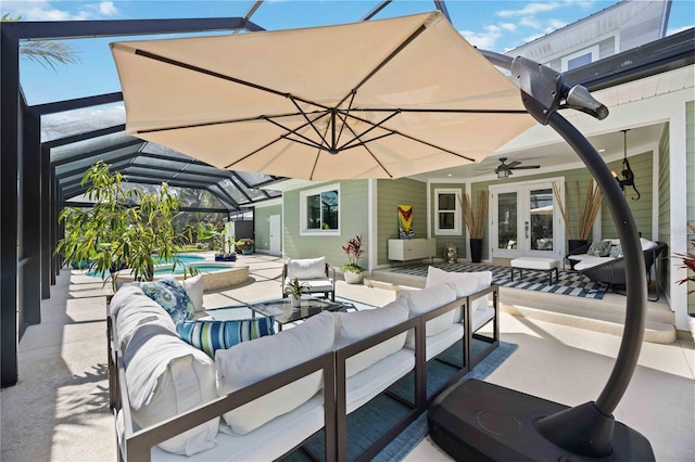 view of patio with a lanai, ceiling fan, a pool with connected hot tub, and an outdoor living space