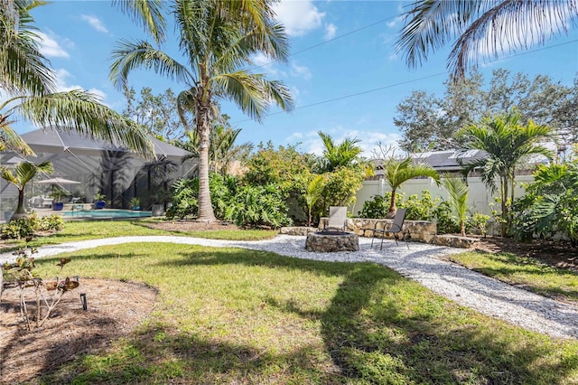 view of yard featuring an outdoor fire pit and a lanai