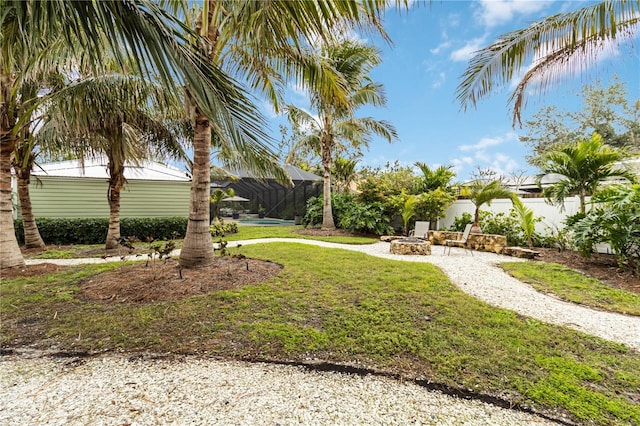 view of yard featuring a fire pit and a lanai