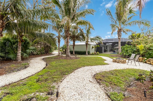 view of yard with glass enclosure and a fire pit