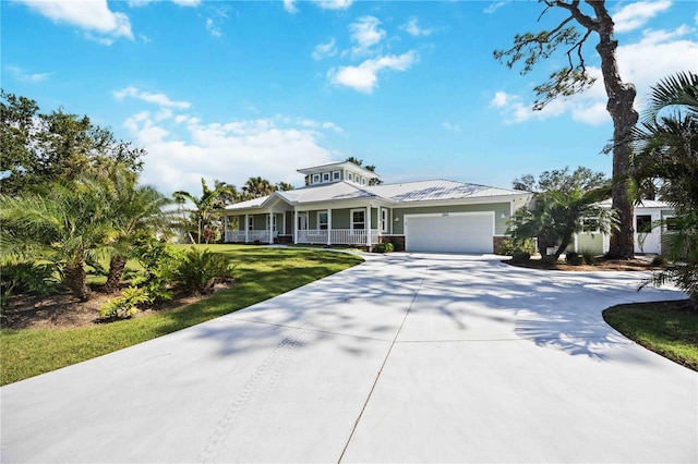 view of front of property with a garage, driveway, a front lawn, and a porch