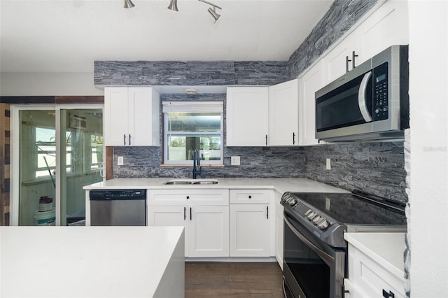 kitchen featuring appliances with stainless steel finishes, a sink, and white cabinetry