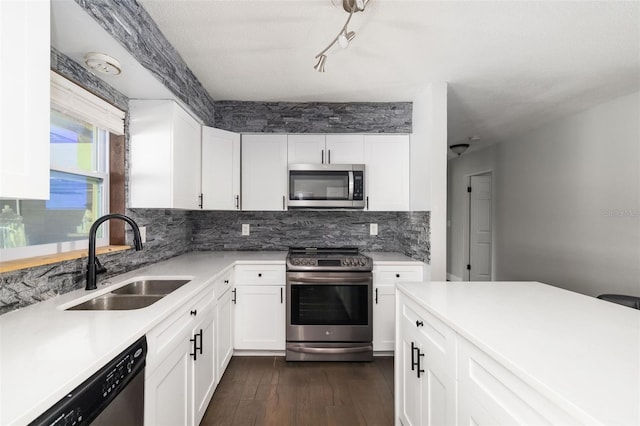 kitchen with stainless steel appliances, dark wood-style flooring, a sink, light countertops, and decorative backsplash