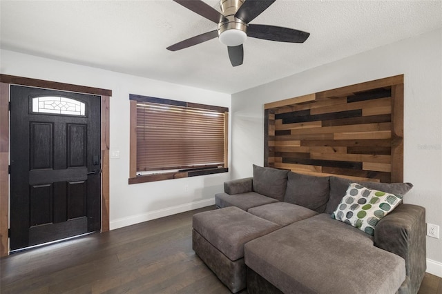 living area featuring a ceiling fan, baseboards, and wood finished floors