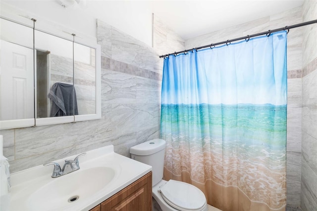 full bathroom with toilet, curtained shower, tile walls, and vanity