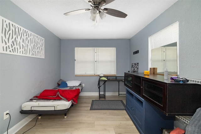 interior space featuring light wood-style floors, ceiling fan, and baseboards