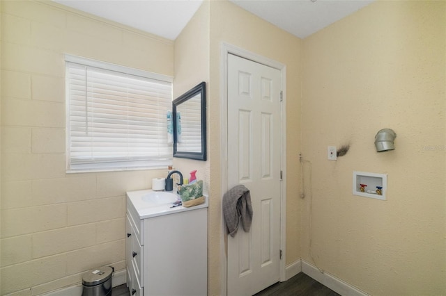 bathroom with wood finished floors, vanity, and baseboards