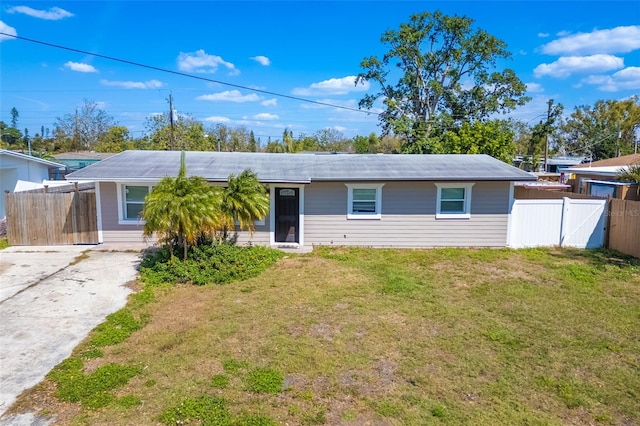 ranch-style house with fence, concrete driveway, and a front yard