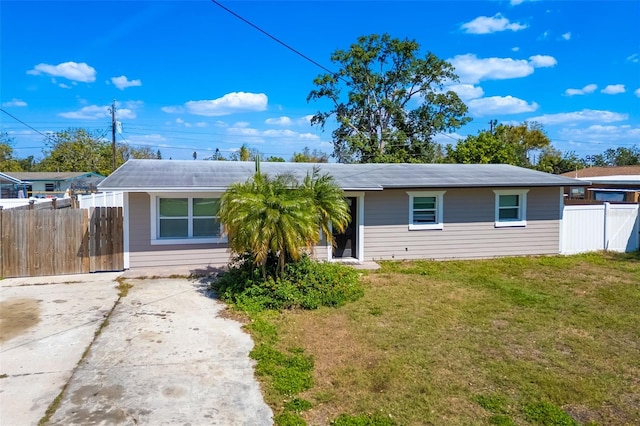 view of front of property featuring driveway, a front yard, and fence